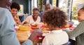 Multi-Generation Family Sitting Around Table At Home Enjoying Meal Together Royalty Free Stock Photo