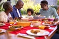 Multi-Generation Family Sitting Around Table At Home Enjoying Meal Together Royalty Free Stock Photo