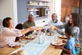 Multi-Generation Family Sitting Around Table At Home Enjoying Meal Together Royalty Free Stock Photo