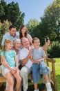 Multi generation family sitting on a bench taking photo of themselves Royalty Free Stock Photo