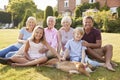 Multi generation family sitting on grass in the garden Royalty Free Stock Photo