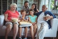 Multi-generation family sitting with popcorn and pizza while watching soccer match Royalty Free Stock Photo