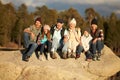 Multi generation family sitting on rocky outcrop near a forest Royalty Free Stock Photo