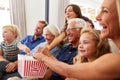 Multi-Generation Family Sitting On Sofa At Home Eating Popcorn And Watching Movie Together Royalty Free Stock Photo