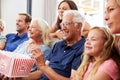 Multi-Generation Family Sitting On Sofa At Home Eating Popcorn And Watching Movie Together Royalty Free Stock Photo