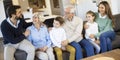 Multi generation family sitting together on the sofa at home and watching TV Royalty Free Stock Photo