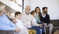 Multi generation family sitting together on the sofa at home and watching TV Royalty Free Stock Photo