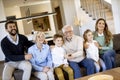 Multi generation family sitting together on the sofa at home and watching TV Royalty Free Stock Photo