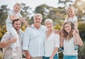 Multi-generation family standing together outside on a sunny day and smiling at the camera. Happy extended caucasian Royalty Free Stock Photo