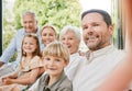 Multi-generation family taking selfie together. Middle aged man sitting with his family and taking picture. Happy