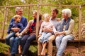 Multi-generation family talking on a bridge in a forest