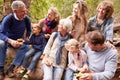 Multi-generation family with teens eating outdoors together