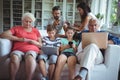 Multi-generation family using laptop, mobile phone and digital tablet Royalty Free Stock Photo