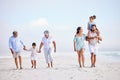 Multi generation family on vacation walking along the beach together. Mixed race family with two children, two parents Royalty Free Stock Photo