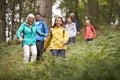 Multi generation family walking downhill on a trail in a forest during a camping holiday, Lake District, UK