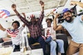 Multi-generation family watching soccer match on television in living room at home Royalty Free Stock Photo