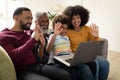 Multi generation family waving while having a video call on laptop at home Royalty Free Stock Photo