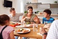 Multi-Generation Mixed Race Family Eating Meal Around Table At Home Together Royalty Free Stock Photo