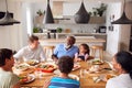 Multi-Generation Mixed Race Family Eating Meal Around Table At Home Together Royalty Free Stock Photo