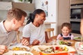 Multi-Generation Mixed Race Family Eating Meal Around Table At Home Together Royalty Free Stock Photo