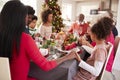 Multi generation, mixed race family holding hands and saying grace at the Christmas dinner table, side view Royalty Free Stock Photo