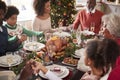 Multi generation mixed race family sitting at Christmas dinner table holding hands and saying grace, elevated view Royalty Free Stock Photo