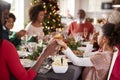 Multi generation mixed race family sitting at Christmas dinner table holding hands and saying grace, selective focus, close up Royalty Free Stock Photo
