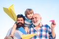 Multi generation. Portrait of happy father giving son piggyback ride on his shoulders and looking up. Happy child Royalty Free Stock Photo