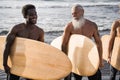 Multi generational surfer men having fun on the beach - Main focus on senior face