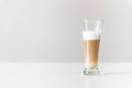 multi-layered coffee in a transparent glass on a gray background and a white table Royalty Free Stock Photo