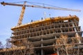 Multi-level concrete building under construction with tower crane; new residential development in the heart of Silicon Valley, San