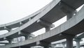 Multi-level concrete highway overpass with curved design. Elevated road structure with pillars, supports. Modern urban Royalty Free Stock Photo