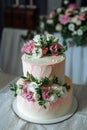 Multi level white and pink wedding cake decorated with fresh flowers