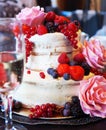 A multi level white wedding cake decorated with ripe bright berries