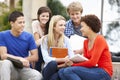 Multi racial student group sitting outdoors Royalty Free Stock Photo
