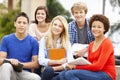 Multi racial student group sitting outdoors Royalty Free Stock Photo