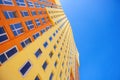 Multi-storey building with many glass windows standing against background of blue sky. Residential buildings, urban real Royalty Free Stock Photo