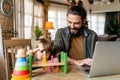 Multi-tasking freelance and fatherhood concept. Working single father with child and laptop computer Royalty Free Stock Photo