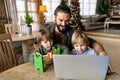 Multi-tasking freelance and fatherhood concept. Working single father with kids and laptop computer Royalty Free Stock Photo