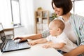 Working mother with baby boy and laptop at home Royalty Free Stock Photo