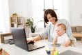 Working mother with baby boy and laptop at home Royalty Free Stock Photo