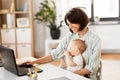 Working mother with baby boy and laptop at home Royalty Free Stock Photo