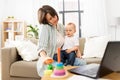 Working mother with baby calling on smartphone