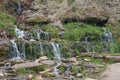 Multi-tiered cascade of clean cold transparent mountain stream on the mountainside. Royalty Free Stock Photo