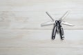 Multi tool with black handles on a white wooden background. Top view of desktop Royalty Free Stock Photo