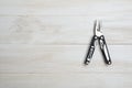 Multi tool with black handles on a white wooden background. Top view of desktop Royalty Free Stock Photo