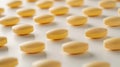 Multi vitamin array of yellow vitamin tablets scattered on a white surface under soft lighting