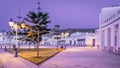 Multi-windowed building stands adjacent to lush green grass and trees in Mdiq, Morocco