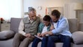 Multiage family members watching photoalbum, strong family bounds, togetherness