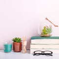 Multicolor books stack, house plants succulents and fragrant candle and sticks. Background for World Book Day. Still